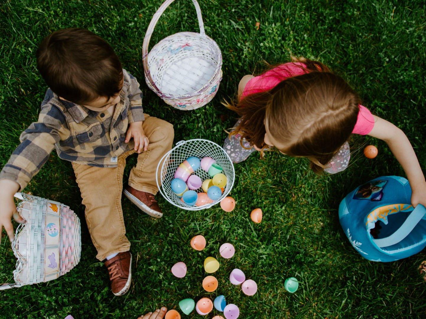 article image: Easter holidays 2023 in Portugal. Pictured are two children on the grass during an egg hunt activity.